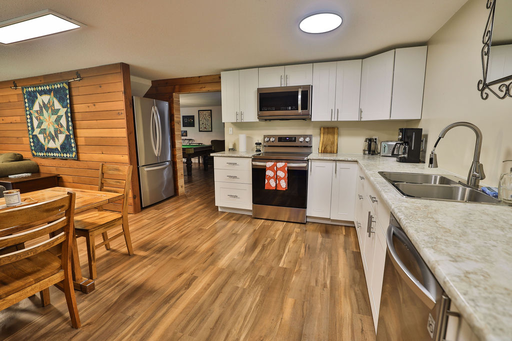 Full kitchen with stainless appliances, dishwasher, and dining table