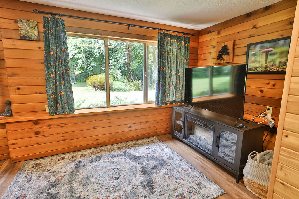 Cedar-panelled living room with TV and electric fireplace